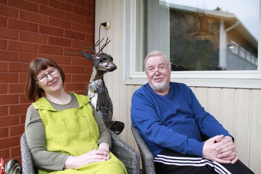 Mikael ja Maria Juudin poseeraavat istuen kotinsa edustalla.